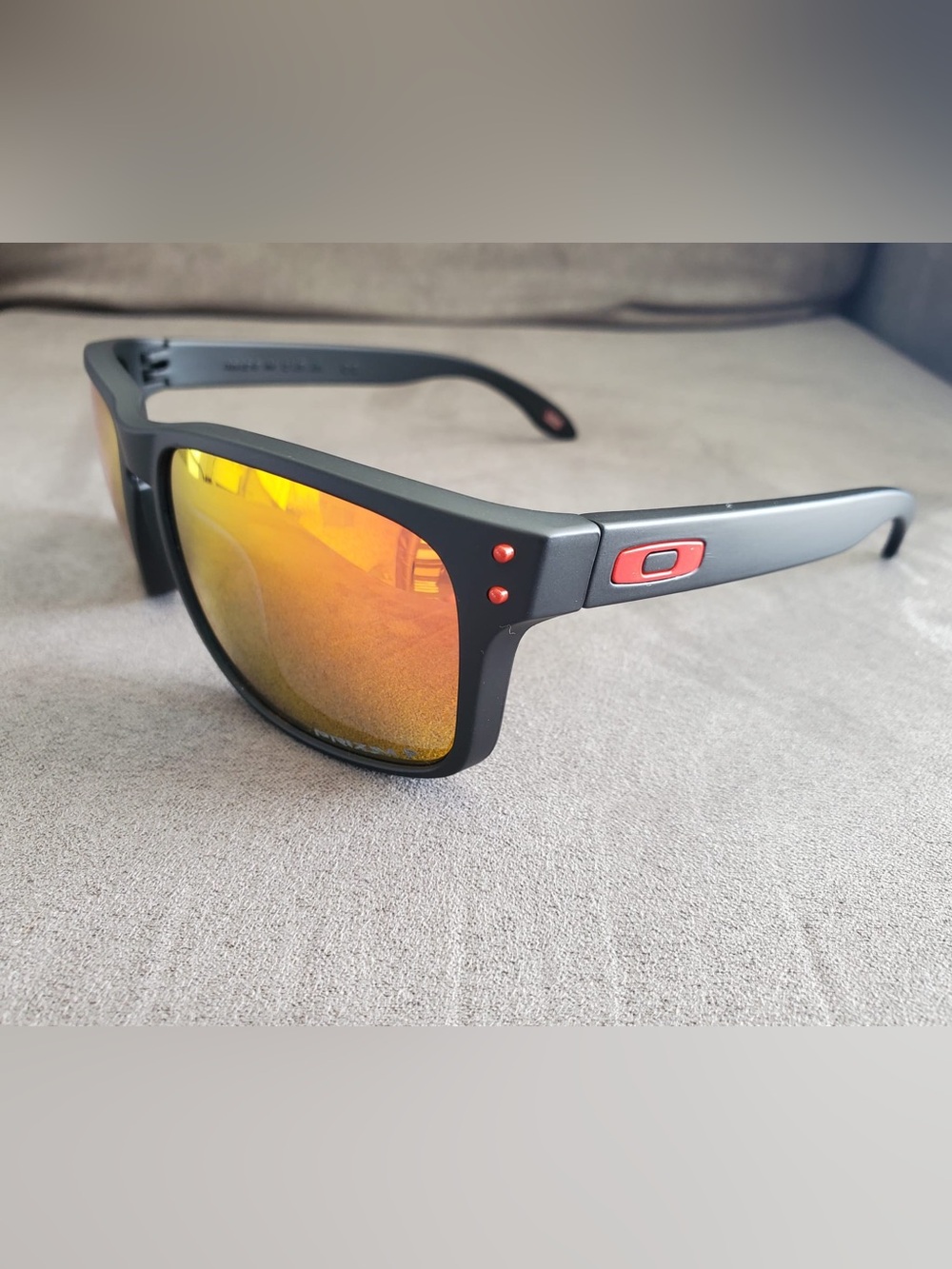 Oakley Matte Black Sunglasses with Red Accents and Yellow-Orange Mirrored Lenses